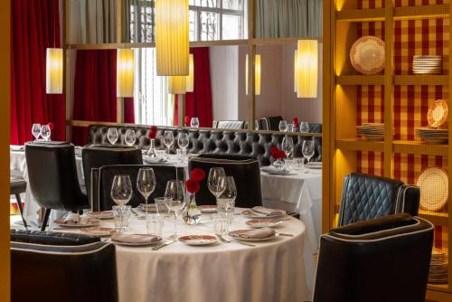 a dining room with tables and chairs with wine glasses at URSO Hotel & Spa, a Small Luxury Hotel of the World in Madrid