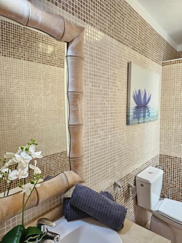 een badkamer met een wastafel en een betegelde muur bij HOLIDAYS BEACH & POOL ,AIRCOND , Las Americas in Arona