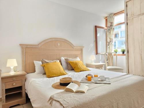 łóżko z kapeluszem i książką w obiekcie HOLIDAYS BEACH & POOL ,AIRCOND , Las Americas w Aronie
