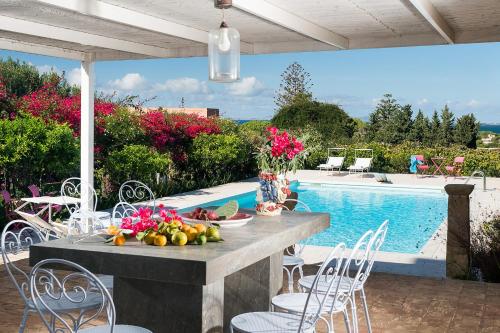 a table with fruit on it next to a pool at Il Giardino Ritrovato in Marsala