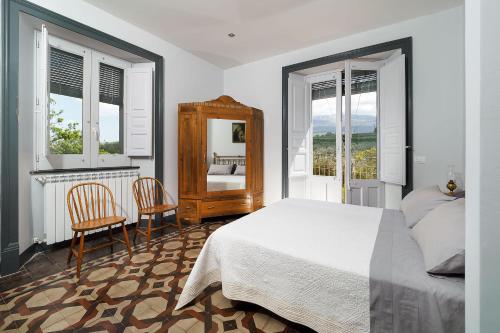 a bedroom with a bed and two chairs and a mirror at Nerello Mascalese in Montelaguardia