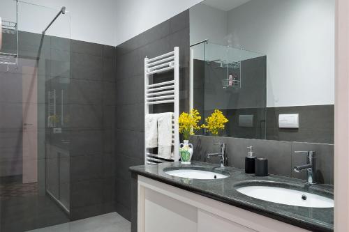 a bathroom with two sinks and a glass shower at Nerello Mascalese in Montelaguardia