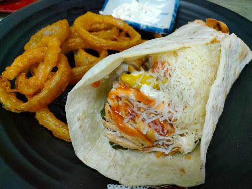 a plate of food with a sandwich and onion rings at Mateoasis in Ko Kood