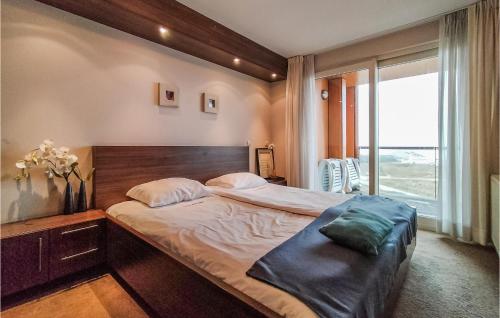 um quarto com uma cama grande e uma janela grande em Beautiful Apartment In Cadzand-bad With Wifi em Cadzand-Bad