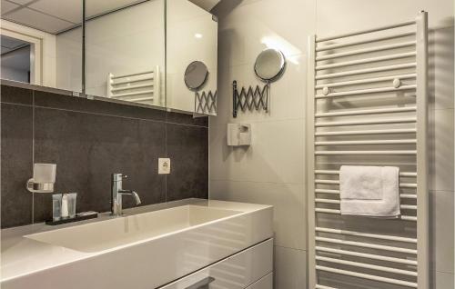 ein weißes Badezimmer mit einem Waschbecken und einem Spiegel in der Unterkunft Beautiful Apartment In Cadzand-bad With Wifi in Cadzand-Bad