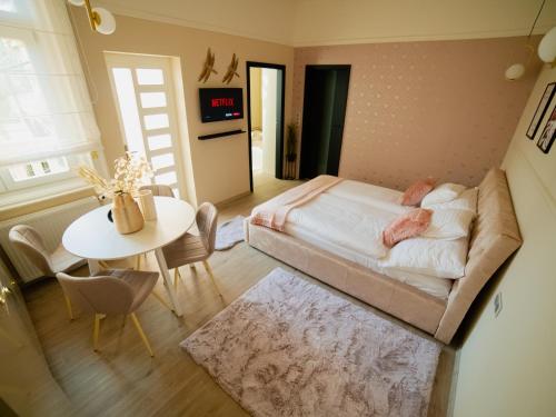a small bedroom with a bed and a table at Dream Apartments in Szeged