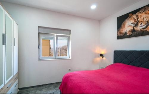 a bedroom with a red bed and a window at Apartment AS MOON with swimming pool in Split