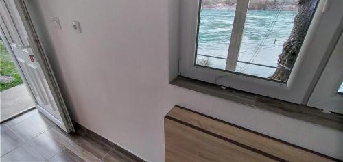 a room with a window with a view of the water at Apartman na Drini in Foča