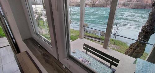 a window with a bench looking out at the water at Apartman na Drini in Foča