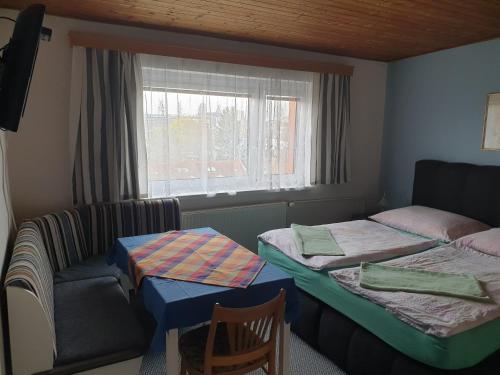 a room with two beds and a chair and a window at Pension Beránek in Prague