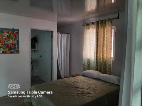 a bedroom with a bed and a window at Oasis en la naturaleza Rancho alto bonito in Las Galeras