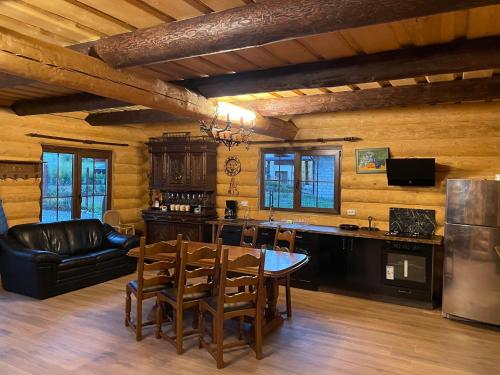 eine Küche und ein Wohnzimmer mit einem Tisch und Stühlen in der Unterkunft Chalet Poligon in Vatra Dornei