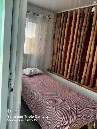 a bedroom with a bed and a window with at Oasis en la naturaleza Rancho alto bonito in Las Galeras
