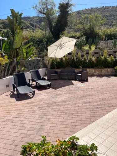 a patio with two chairs and an umbrella at Residenza De Luca Apartment in Tropea
