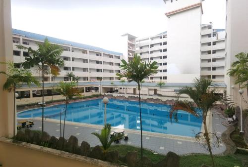 einen Blick auf den Pool vom Balkon eines Gebäudes in der Unterkunft 3 Rooms 2 parking 10pax PSR Comfy Sofa&Bed near MRT Eateries McD in Seri Kembangan