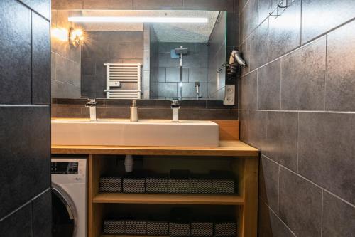 une salle de bain avec un lavabo et un miroir dans l'établissement Les Anémones, aux Orres