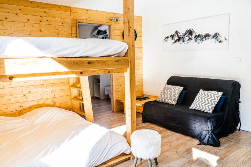 a bedroom with two bunk beds and a chair at Les Anémones in Les Orres