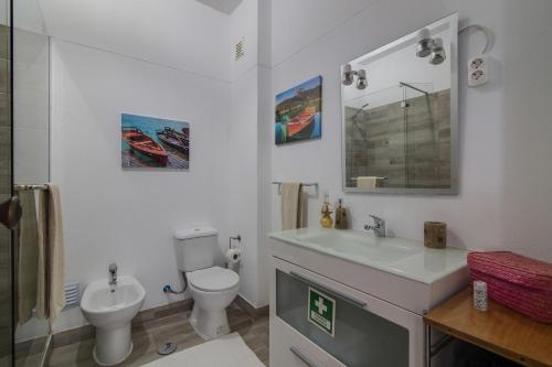 een witte badkamer met een toilet en een wastafel bij Casa de Mar in Moncarapacho