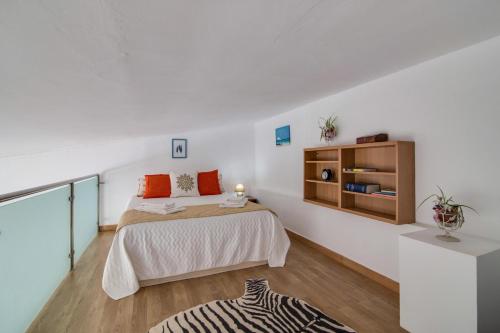 een witte slaapkamer met een bed en een kast bij Casa de Mar in Moncarapacho