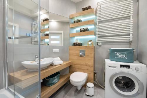 a bathroom with a sink and a washing machine at Ursynów Geometric Homey Apartment in Warsaw