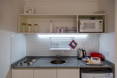 una pequeña cocina con fregadero y microondas en AIRESSOHO 525A en Buenos Aires