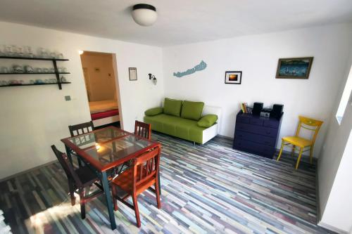 uma sala de estar com uma mesa e um sofá verde em pRezident Ház em Rezi