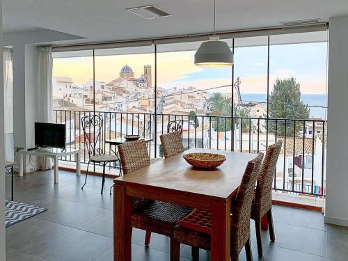 a dining room with a table and chairs and a large window at Hostal Fornet Altea in Altea