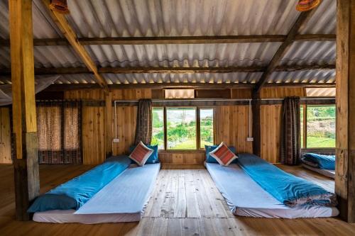 una camera con tre letti in una casa di legno di River mountain view homestay a Sa Pa