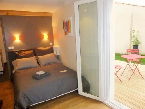 Schlafzimmer mit einem Bett und einer Glasschiebetür in der Unterkunft Chambre d'hôtes "Mirabel" in Saint Jean