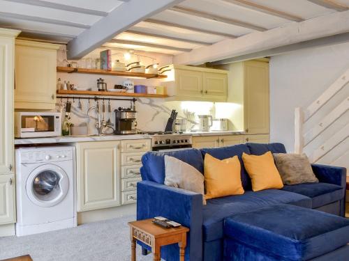 a living room with a blue couch in a kitchen at Weavers Cottage in Holmfirth