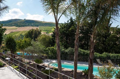 ブゼート・パリッツォーロにあるBaglio Maranzano - Titiの木々とブドウ畑のあるプールの景色を望めます。