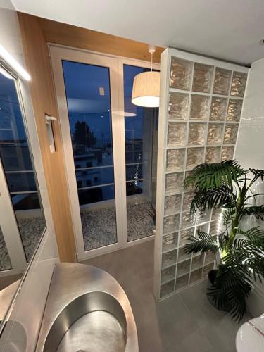 a bathroom with a stainless steel toilet and a plant at Hostal Fornet Altea in Altea