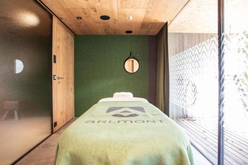 a bed in a room with a green wall at Hotel Arlmont 4 Stern Superior in Sankt Anton am Arlberg