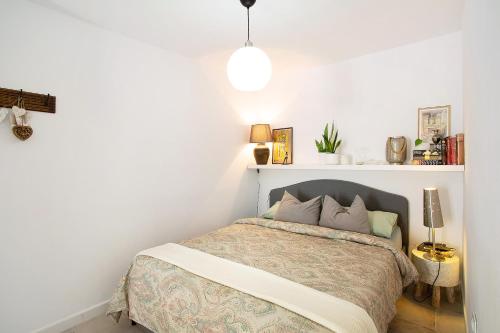 um quarto com uma cama num quarto branco em Casa Las Caracolas em Castillo del Romeral