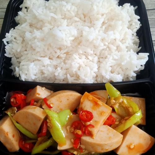 a black container with rice and tofu and vegetables at Mateoasis in Ko Kood