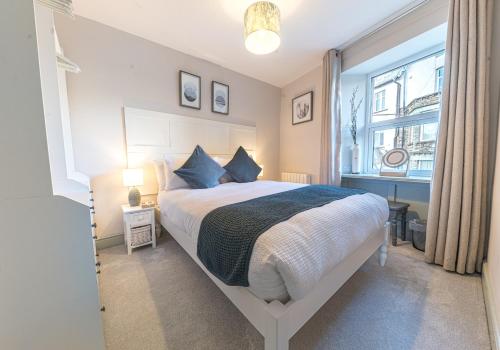 ein Schlafzimmer mit einem großen Bett und einem Fenster in der Unterkunft Victoria Apartment, Derwent House in Keswick