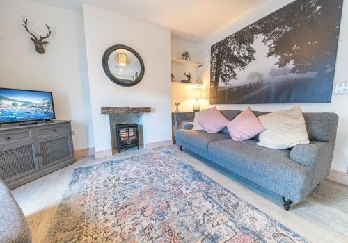 a living room with a couch and a fireplace at Withesike, Derwent House in Keswick