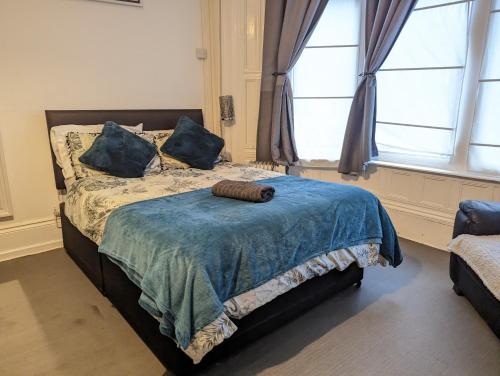 a bedroom with a bed with a blue blanket and a window at 1 Bedroom Studio in a Supurb Area of Cardiff in Cardiff