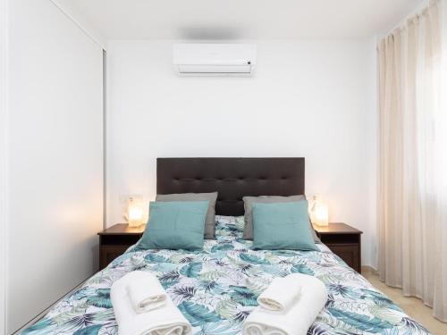 Lightbooking Candelaria Tenerife في Araya: غرفة نوم عليها سرير وفوط