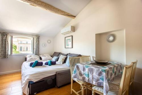 sypialnia z łóżkiem, stołem i kanapą w obiekcie 6 - Charming studio,Heart old town, beach walk w mieście Antibes