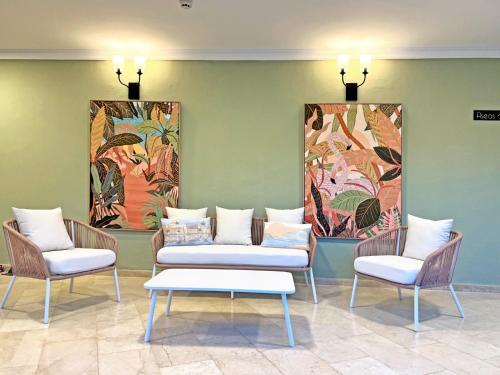 two chairs and a table in a room with paintings at Moon Dreams Fuengirola in Fuengirola