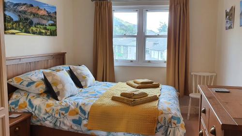 a bedroom with a bed with towels on it at Skiddaw. 20 Greta Grove House in Keswick