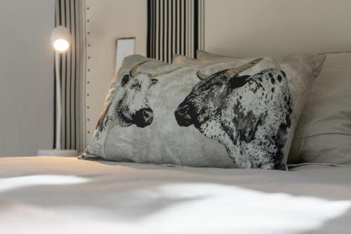two cows on a pillow on a bed at Views over Wilderness in Wilderness