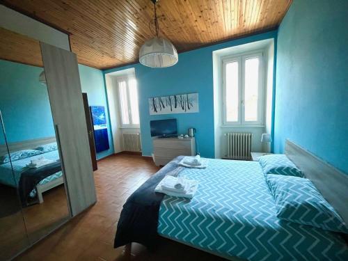 a blue bedroom with a bed and a mirror at La Locanda dell'Oreste in Dizzasco