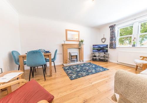 a living room with a dining table and a fireplace at Riverside View in Keswick