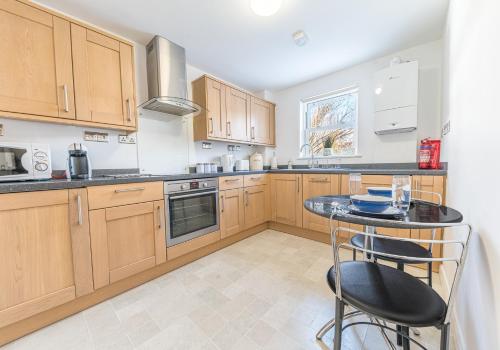 a kitchen with wooden cabinets and a table with chairs at Riverside View in Keswick