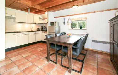 een keuken met een houten tafel en stoelen bij 2 Bedroom Nice Home In Ijhorst in IJhorst