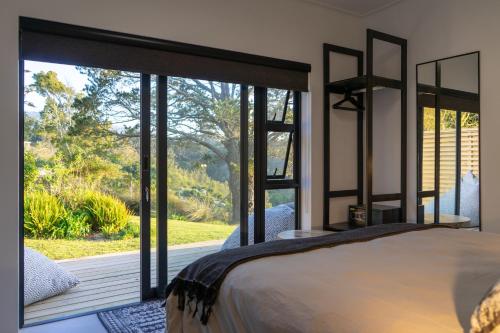 a bedroom with a large window with a view of a deck at Views over Wilderness in Wilderness