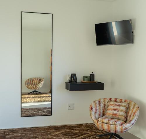 a mirror and a chair in a room at Views over Wilderness in Wilderness