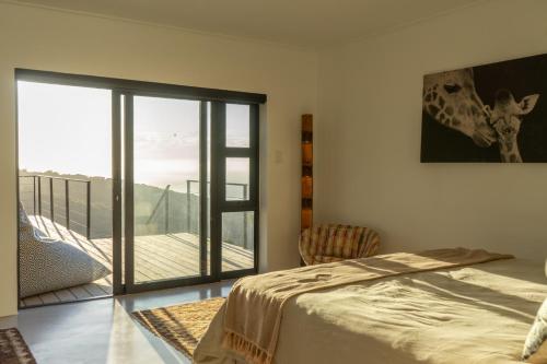 a bedroom with a bed and a balcony at Views over Wilderness in Wilderness